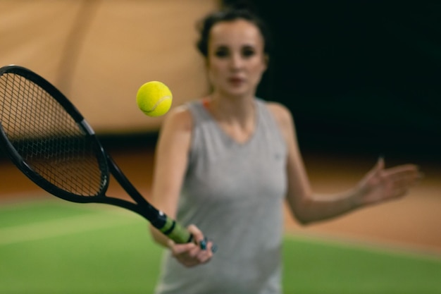 Tennis woman player playing training with racket and ball at court