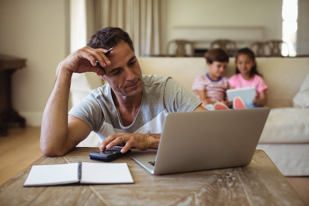 Tense man with hand on forehead sitting in living room