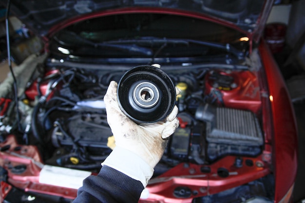 tension roller of the generator in the hand of the master in the garage