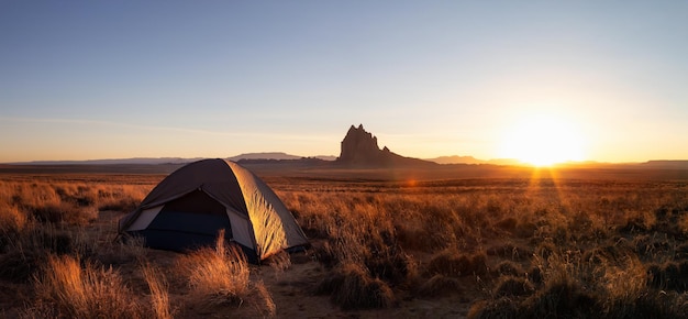 Tent in the dry desert with a mountain peak in the background