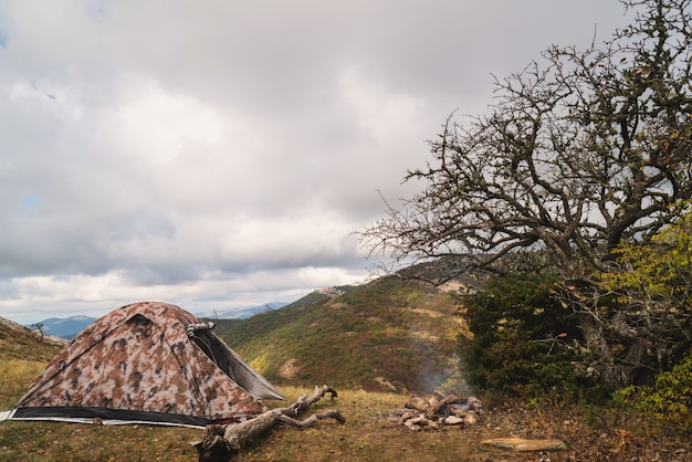 Tent in the mountains near a campfire on a hike in a tourist camp, activity, rest, relaxation, silence