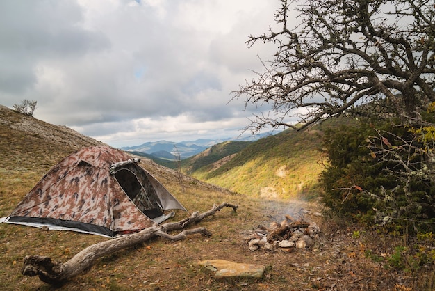 Tent in the mountains near a campfire on a hike in a tourist camp, activity, rest, relaxation, silence