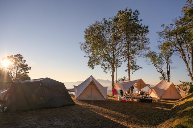 Tents camping in campsite on hill with sunrise over mountain at national park Leisure activity Recreational pursuit Summer and holidays concept