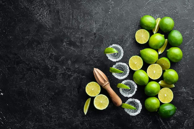 Tequila salt and lime Alcohol On a black stone background Top view Free space for your text