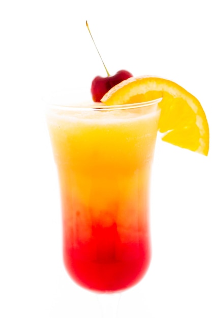 Tequila sunrise cocktail with orange wedge and cherry as a garnish.