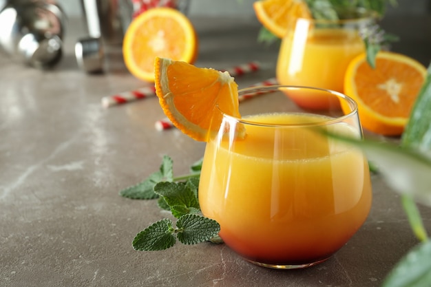 Photo tequila sunrise cocktails on gray textured table, close up