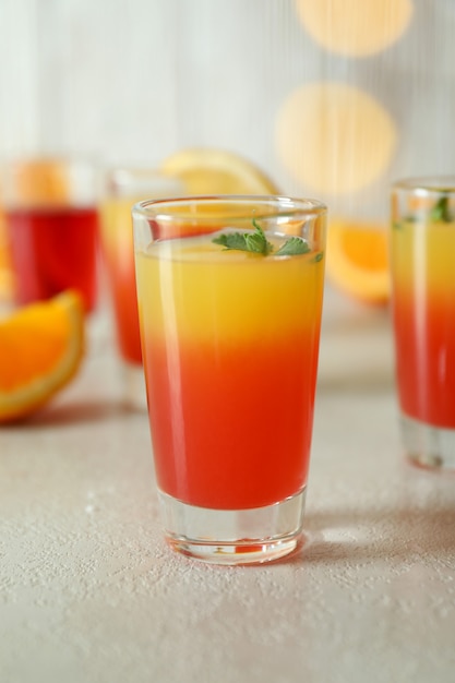 Tequila sunrise cocktails on white textured table, close up