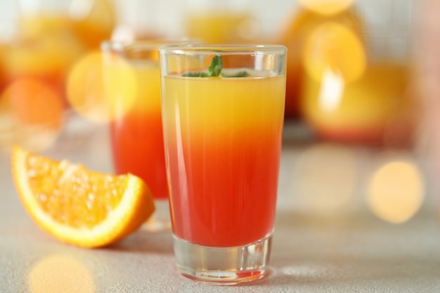 Tequila sunrise cocktails on white textured table, close up