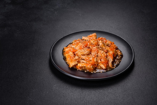 Teriyaki chicken with sauce sesame herbs and spices on a dark background