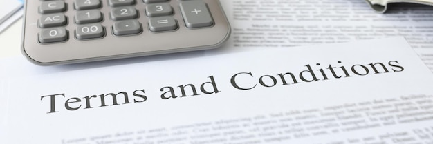 Terms conditions document with calculator lies on table banking commercial offers concept