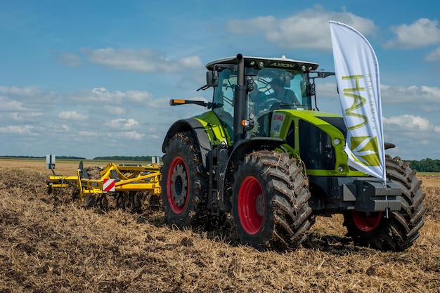 TERNOPIL REGION, UKRAINE - August 10, 2021: tractor with disc harrow, soil cultivation system in operation at the demonstration of agricultural machinery, exhibition of the company Lan