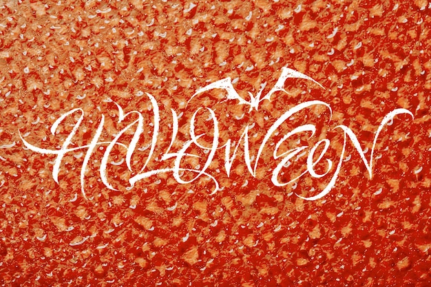 Terrible and beautiful inscription Halloween on water drop surface