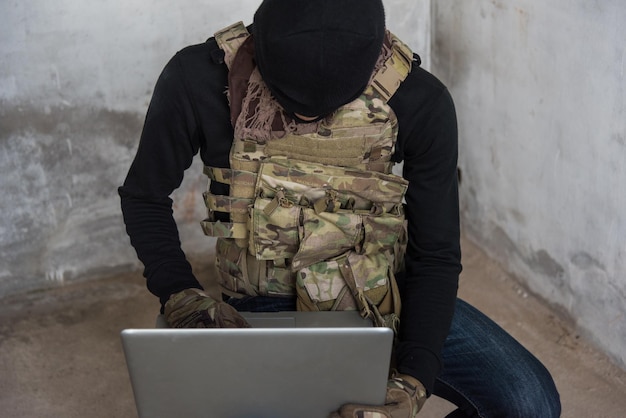 Terrorist man cyber hacker hacking internet to access steal information by laptop computer, robber criminal concept