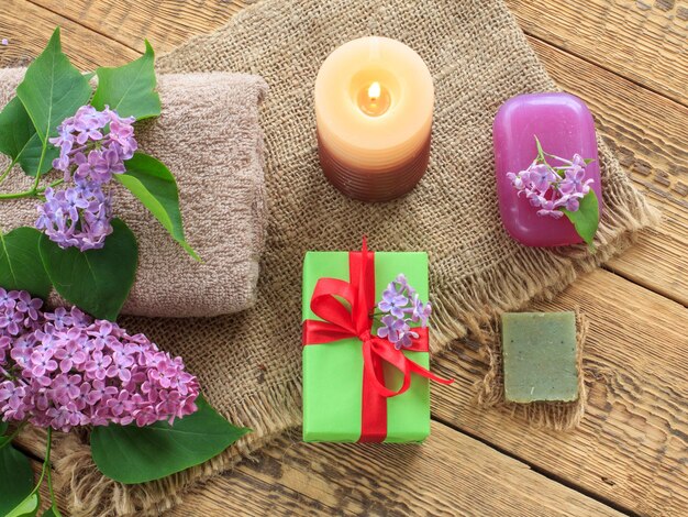 Terry towel soap for bathroom procedures burning candle gift box and lilac flowers on sackcloth