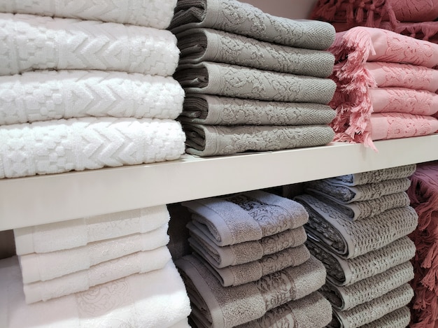 Terry towels of various colors are folded neatly on the shelves