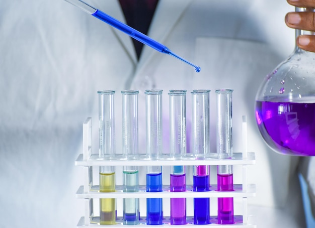 Test tube with color solution. Test tube in test tube stand. Scientist taking color solution in a test tube.