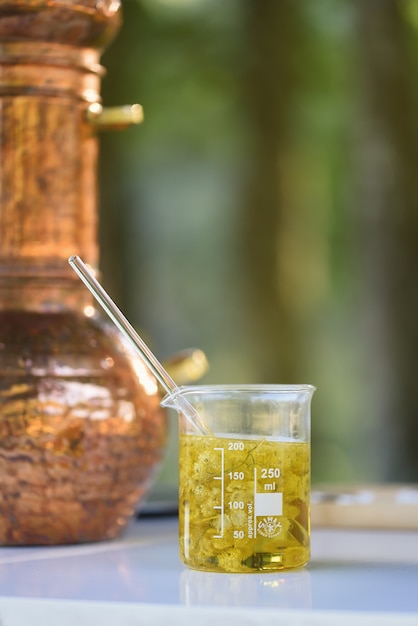 Test tube with essential oil blended with flowers and bottom still