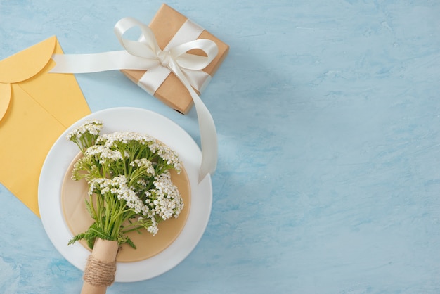 Tet Holiday Concept. Gold Envelope (Lucky money) on table with Table setting with Plate and Flowers.