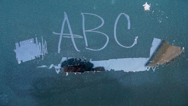 text abc written on the frozen window of a car in cold november morning