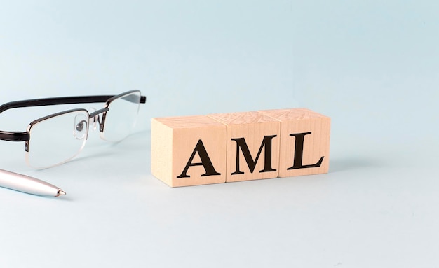 Text AML written on the wooden cubes on blue background