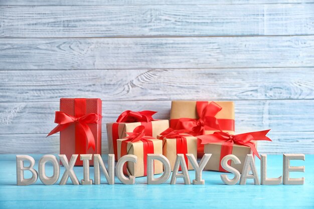 Photo text boxing day sale and gift boxes on table