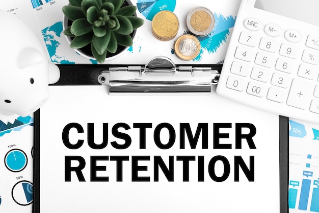 Text Customer Retention on clipboard. Piggy, coin, calculator, charts. Business concept. Flat lay.