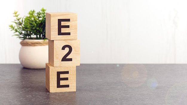 Text E2E on wooden dice standing on top of each other