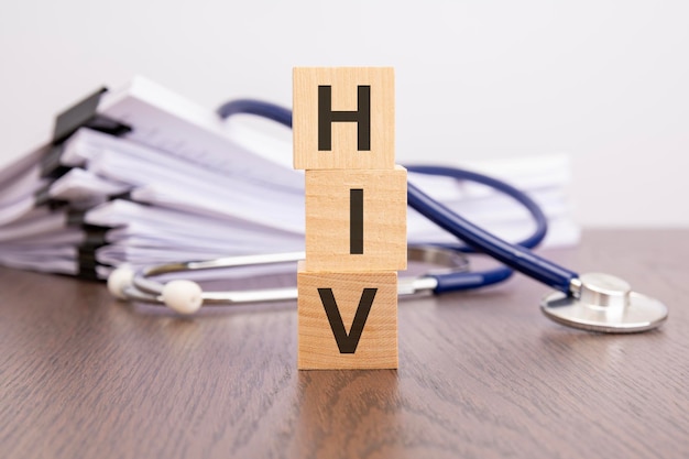 Text HIV written on wooden blocks near a stethoscope on a paper background medical concept