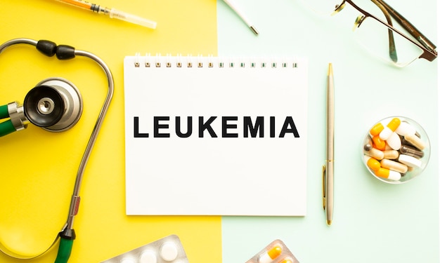 Text LEUKEMIA on notebook with stethoscope and pen on yellow surface