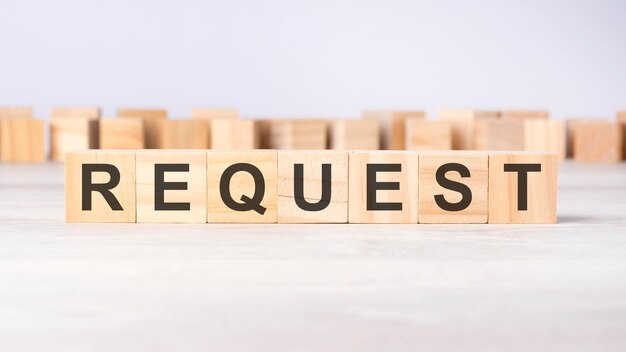 Text REQUEST on wooden cubes on bright grey background square wood blocks top view flat