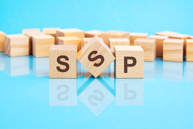 The text SSP written on the wooden cubes in black letters the cubes are located on a bright blue glass surface concept word forming with cubes on background SSP short for Sell Side Platform