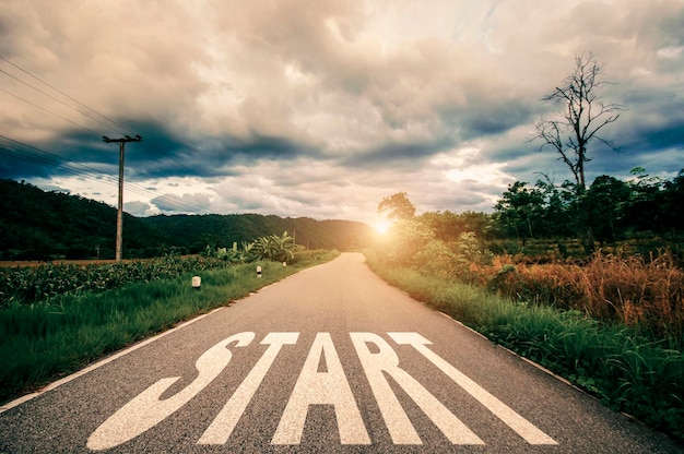 Text Start written on the road in the middle of asphalt road with overcast sky and sunset Concept of planning and challenge or career path business plan strategy opportunity and change my life