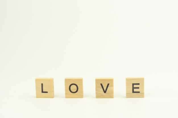 Text wooden blocks spelling the word LOVE on white background