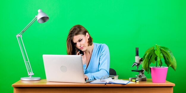 Texting to colleague information Business communication woman with microscope on table businesswoman talking on phone woman work in office at laptop secretary use mobile phone at workplace