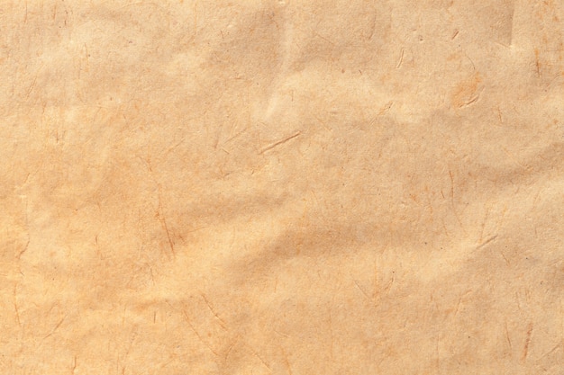 Texture of beige old paper, crumpled background. Vintage brown surface. Structure of craft cardboard.