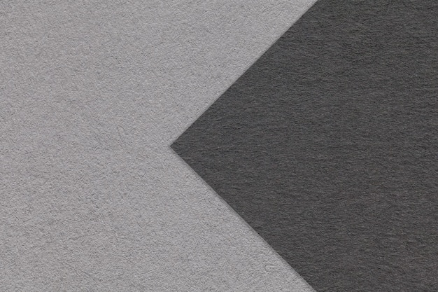 Texture of black and gray paper background half two colors with arrow macro Structure of dense craft grey cardboard