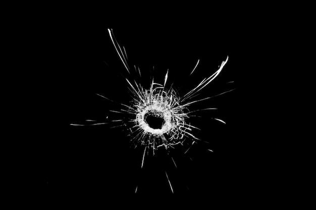 Photo texture of broken glass. hole from a ball on a black background.