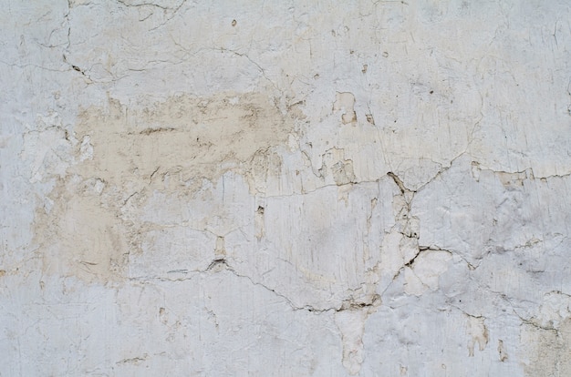 Texture of a cement grey wall with cracks and holes