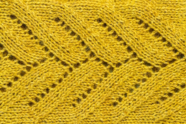 The texture of a color of mustard knitted yarn. Knitted and winter clothes 