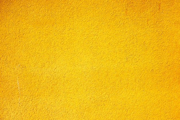 The texture of the concrete wall painted in yellow