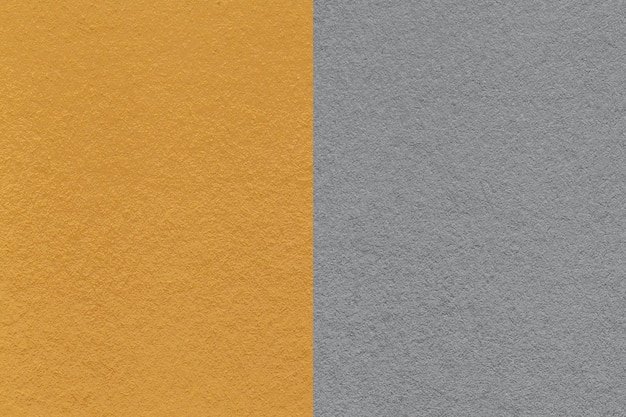 Texture of craft dark yellow and gray paper background half two colors macro Structure of vintage dense ocher cardboard Felt backdrop closeup