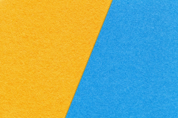 Texture of craft yellow and light blue paper background half two colors macro