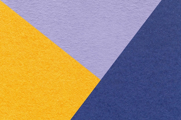 Texture of craft yellow violet and navy blue shade color paper background macro Structure of vintage abstract cardboard with geometric shape and gradient Felt backdrop closeup