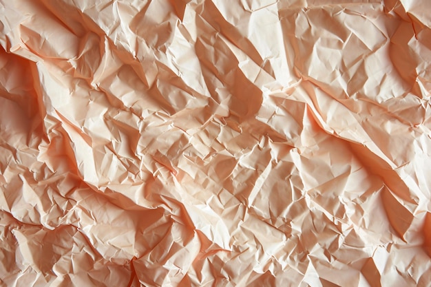 Texture of crumpled peach color paper Sheet of crumpled paper for background wallpaper