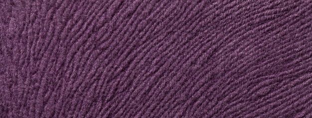 Texture of dark violet textile background from a soft wool material macro Fabric with purple wavy pattern