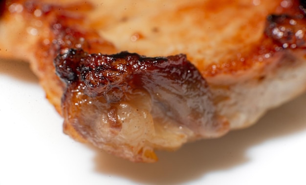 Texture of fried meat close up A fatty piece of pork at a large approximation Harm from meat fried in oil