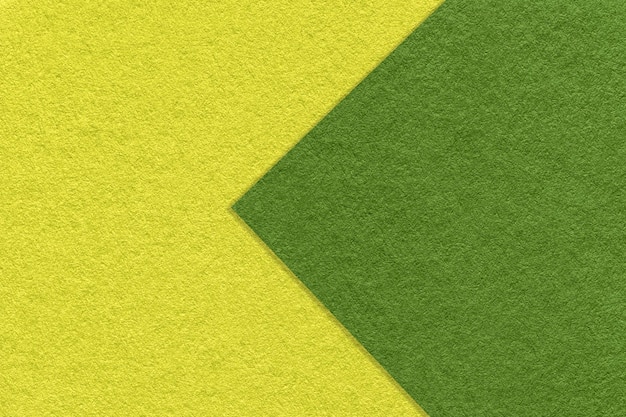 Texture of green and yellow paper background half two colors with arrow macro Structure of olive craft cardboard