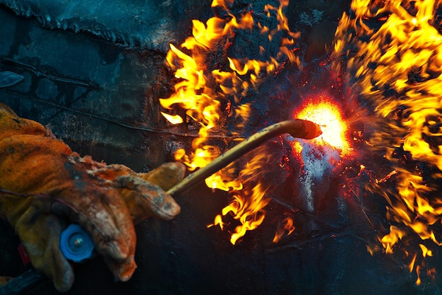 The texture of hot metal from acetylene welding Welder's hands in protective gloves during operation