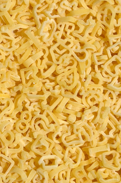 Texture of a lot of curly raw yellow pasta