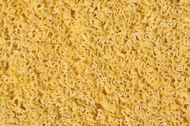 Texture of a lot of curly raw yellow pasta